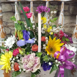 Colorful mixed flower basket with sunflower, iris, daisies, and a purple ribbon bow