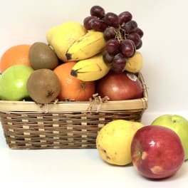 Basket of assorted fruit with grapes, bananas, apples, oranges, and kiwis