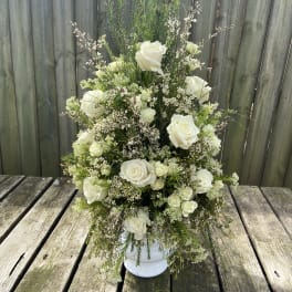 Tall white rose arrangement in a white vase