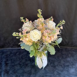 Bouquet of white roses and peach flowers in a glass vase