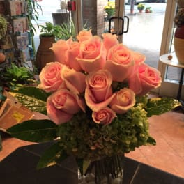 Pink roses arranged in a clear square vase
