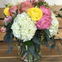 Pink and yellow flower arrangement in a glass vase