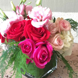 Bouquet of pink and red roses with pale pink blooms in a glass vase