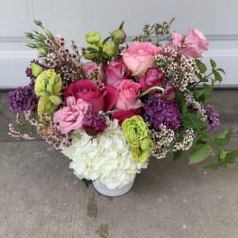 Mixed pink and white floral arrangement in a white vase