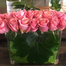 Pink roses arranged in a clear rectangular vase