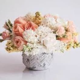 Bouquet of blush and white flowers in a patterned vase