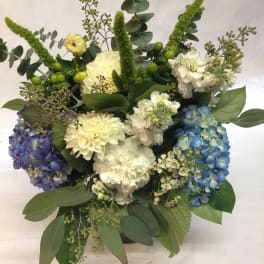 Mixed bouquet with blue, purple, and white hydrangeas and greenery