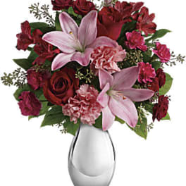 Red and pink floral arrangement in a clear glass vase