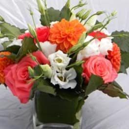 Bouquet of pink, orange, and white flowers in a dark vase