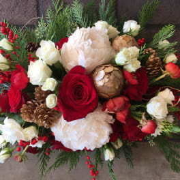 Red and white floral arrangement with pinecones and berries