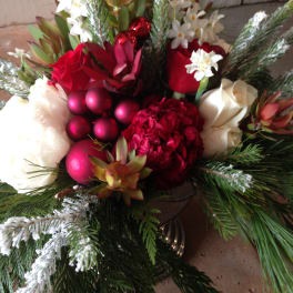 Holiday bouquet with red and white flowers, pine branches, and red ornaments