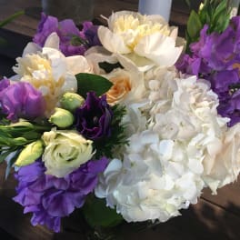 Bouquet of white hydrangeas, purple blooms, and cream roses