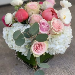 Pink and white roses with white hydrangeas in a square vase