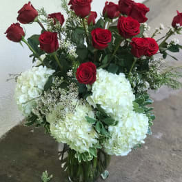 Red roses and white hydrangeas in a clear glass vase