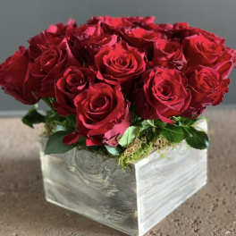 Red roses arranged in a square wooden box