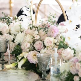 Pastel floral centerpiece with roses, dahlias, and white orchids