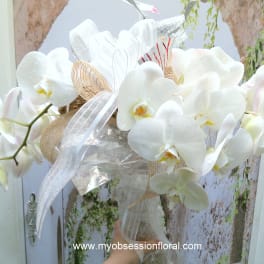 White orchid bouquet with ribbon and sheer wrap