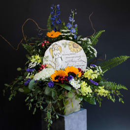 Sympathy floral arrangement with a memorial plaque and mixed flowers