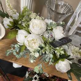 White floral arrangement with peony-like blooms in a clear vase
