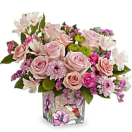 Pink roses and mixed blooms in a decorated glass vase