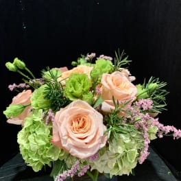 Peach roses and green hydrangeas in a glass vase