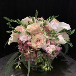 Blush roses and white calla lilies in a glass bowl vase
