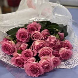 Bouquet of pink roses wrapped in white mesh paper