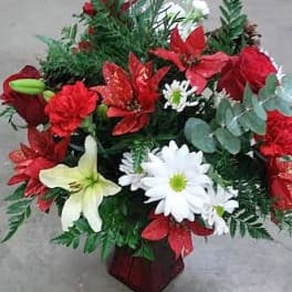Red and white floral arrangement in a red vase