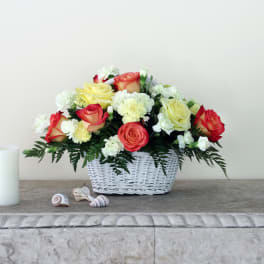 Basket of red, yellow, and white roses with carnations