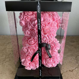 Pink rose-shaped arrangement in a clear gift box with a black ribbon