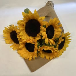 Bouquet of yellow sunflowers wrapped in burlap and kraft paper