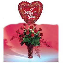 Red roses in a clear vase with a heart-shaped "I Love You" balloon