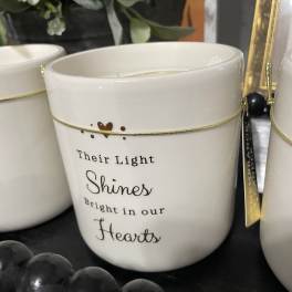 White memorial candle holder with the words "Their Light Shines Bright in our Hearts"
