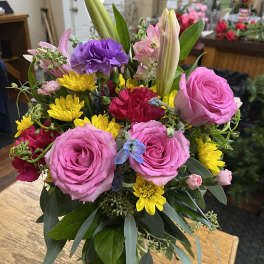 Mixed bouquet with pink roses, yellow daisies, and lilies