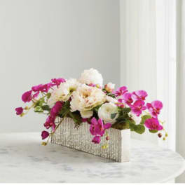 Pink orchids and white flowers in a rectangular textured vase