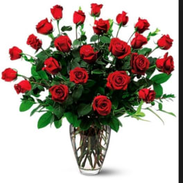 Red roses arranged in a clear glass vase