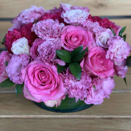Pink roses and carnations arranged in a low glass bowl