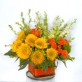 Sunflower and orange rose arrangement in a square glass vase