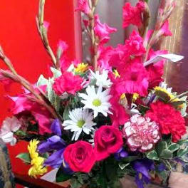 Bright mixed bouquet with pink roses and white daisies in a glass vase