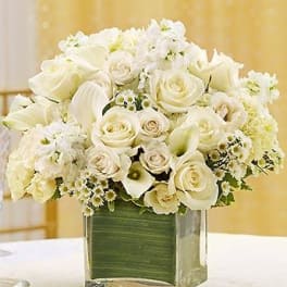 White rose and calla lily arrangement in a clear square vase