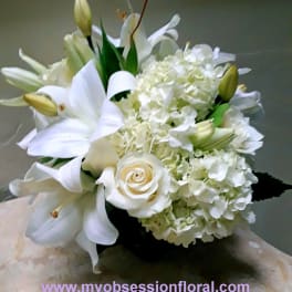 White lilies and hydrangeas arranged with a white rose
