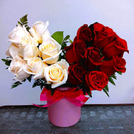Bouquet of red and white roses in a pink box with a ribbon