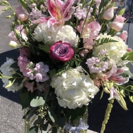 Pink and white mixed bouquet with lilies, roses, and hydrangeas in a clear vase
