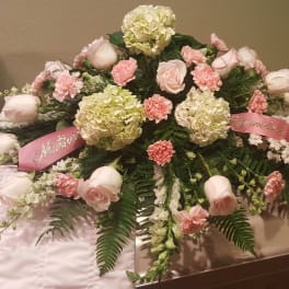 Pink and white floral casket spray with roses and carnations