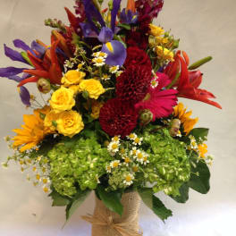 Colorful mixed bouquet in a burlap-wrapped vase