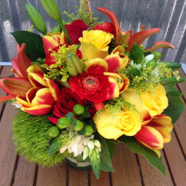 Bright bouquet of red and yellow flowers in a glass vase