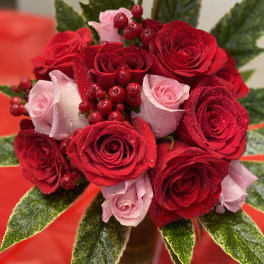 Bouquet of red and pink roses with berry accents