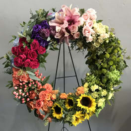 Large floral wreath on a black stand with multicolored blooms