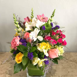 Colorful mixed bouquet in a square glass vase