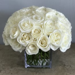 White rose bouquet in a clear square vase
